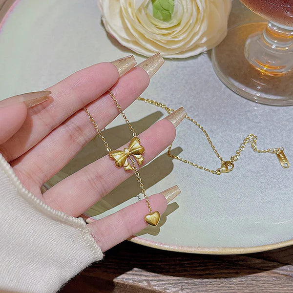 Svarnika Jewels Gold Plated Stainless Steel Anti Tarnish Heart Themed Bow Inspired Pendant Necklace